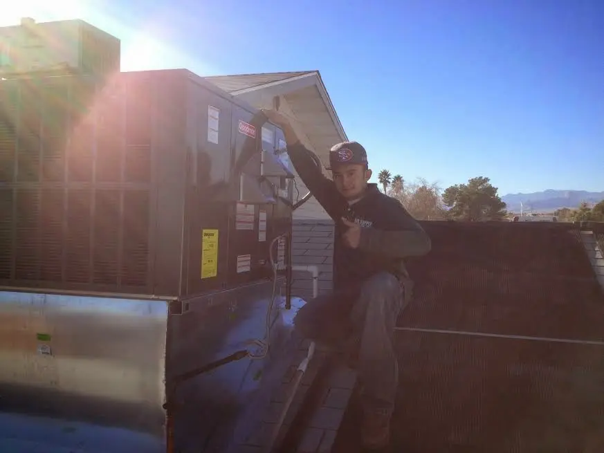 HVAC technician performing AC Tune-Up on a rooftop unit in Braselton